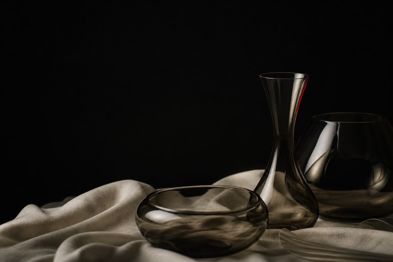 Editorial still life with smoked glass and ivory fabric